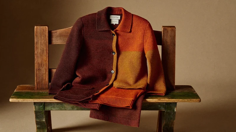 Cardigan e pantaloni in lana nei toni caldi dell'autunno su una panca